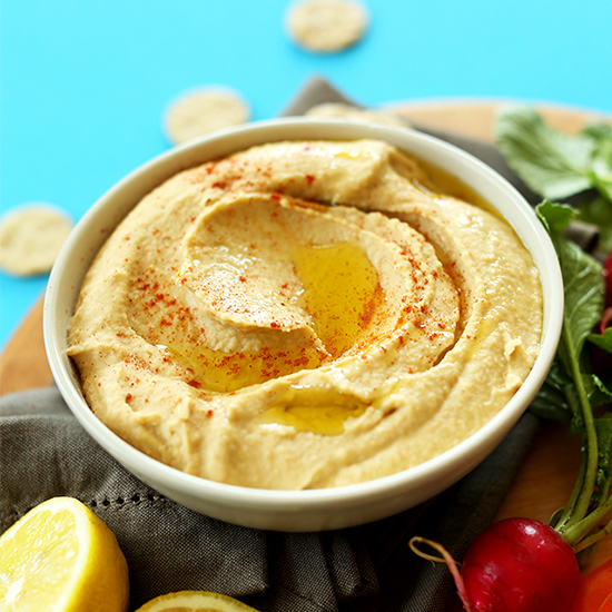 Bowl of homemade hummus topped with olive oil and paprika