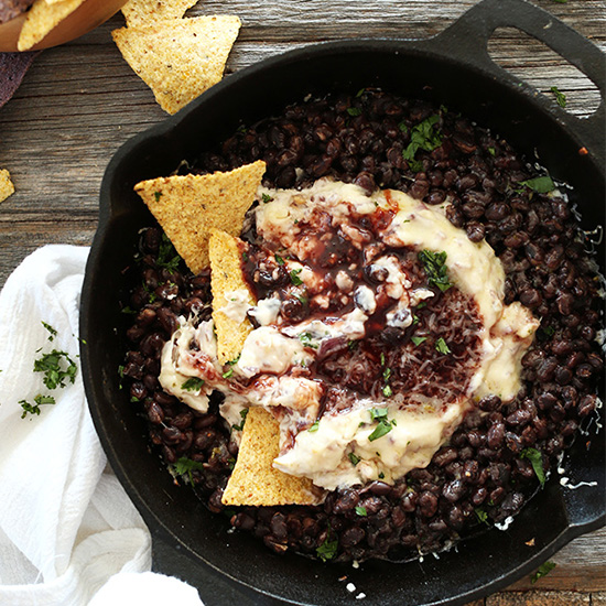 Tortilla chips in and beside a skillet of Black Bean Raspberry Chipotle Dip