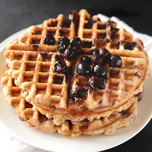 Plate with a stack of two Blueberry Lemon Waffles topped with fresh blueberries
