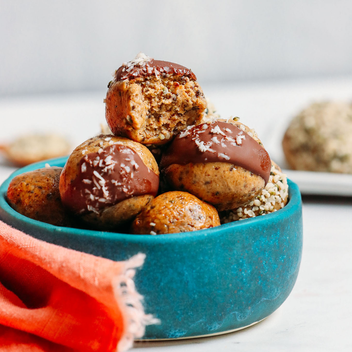 Bowl piled high with our grain-free, low sugar Protein Balls topped with chocolate