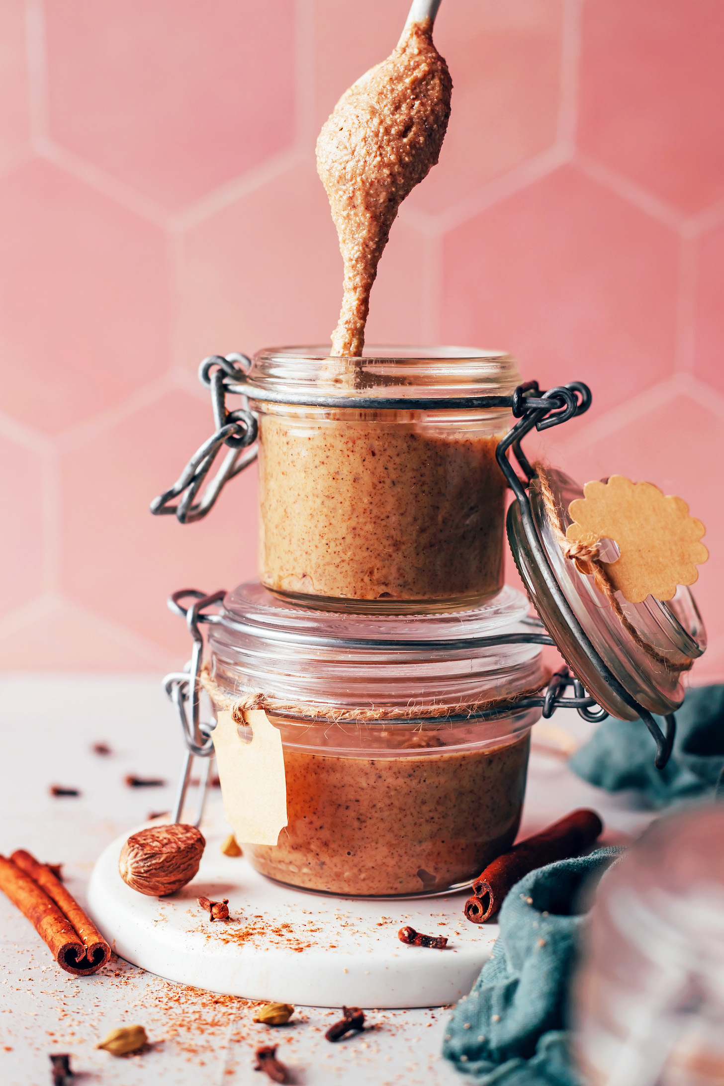 Chai-spiced nut butter dripping off a spoon into a jar