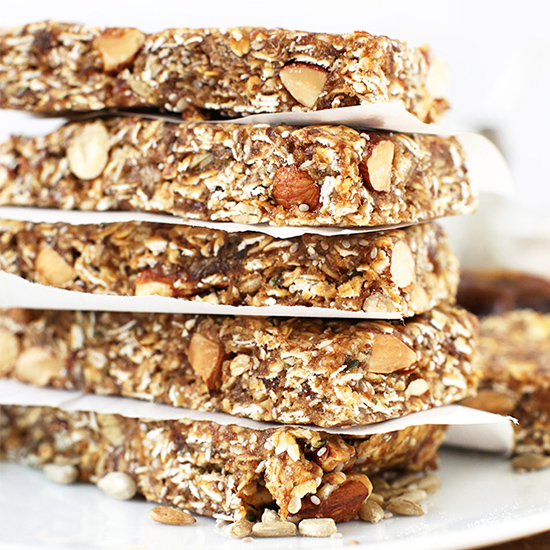 Tall stack of Super Seedy Granola Bars separated by pieces of parchment paper